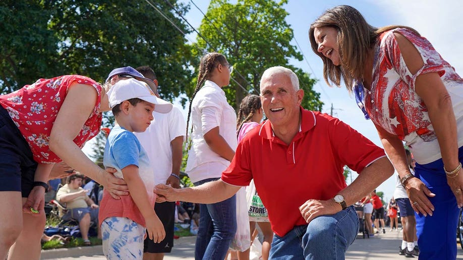 Former Vice President and 2024 Presidential Candidate Mike Pence walks alongside Karen Pence in the Urbandale 4th of July Celebration