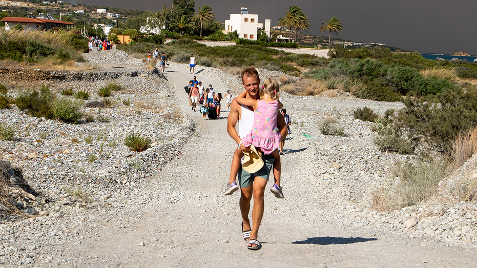 Tourists flee vacation destination ‘in just swimsuits’ as wildfires rage