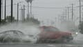 Vehicles splash up water during heavy rains from Hurricane Hilary, in south Los Angeles, California, on August 20, 2023.