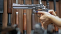 A woman aims a gun at a gun shop. (Photo by Miguel SCHINCARIOL / AFP) (Photo by MIGUEL SCHINCARIOL/AFP via Getty Images)