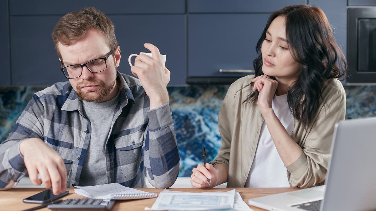 Photo of a husband and wife looking up their insurance company.