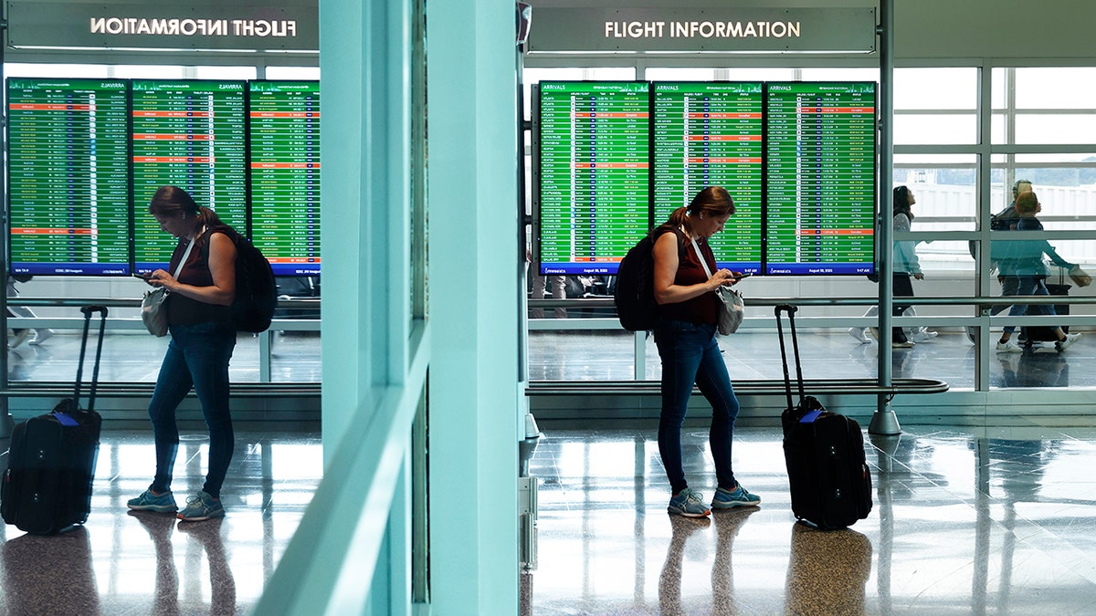 Viajante verifica telefone no Aeroporto Nacional Reagan na área de Washington