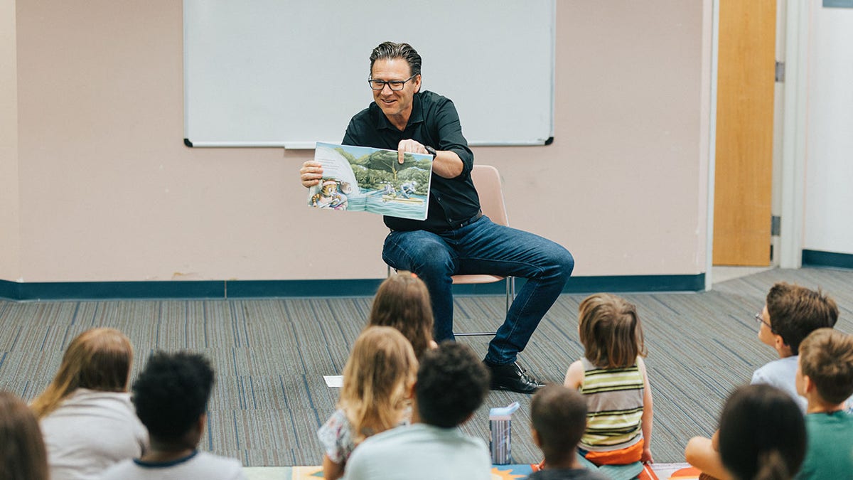 Pastor Brad Jurkovich reading story book to children