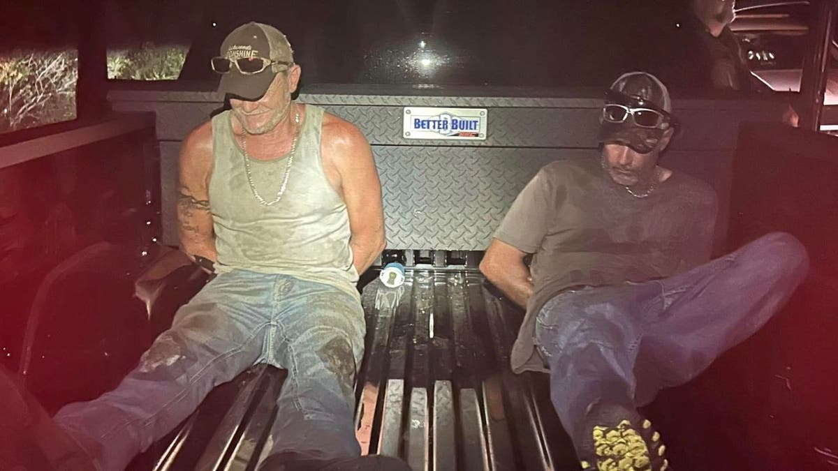 Casey Judd Howe and other arrested suspect in back of truck