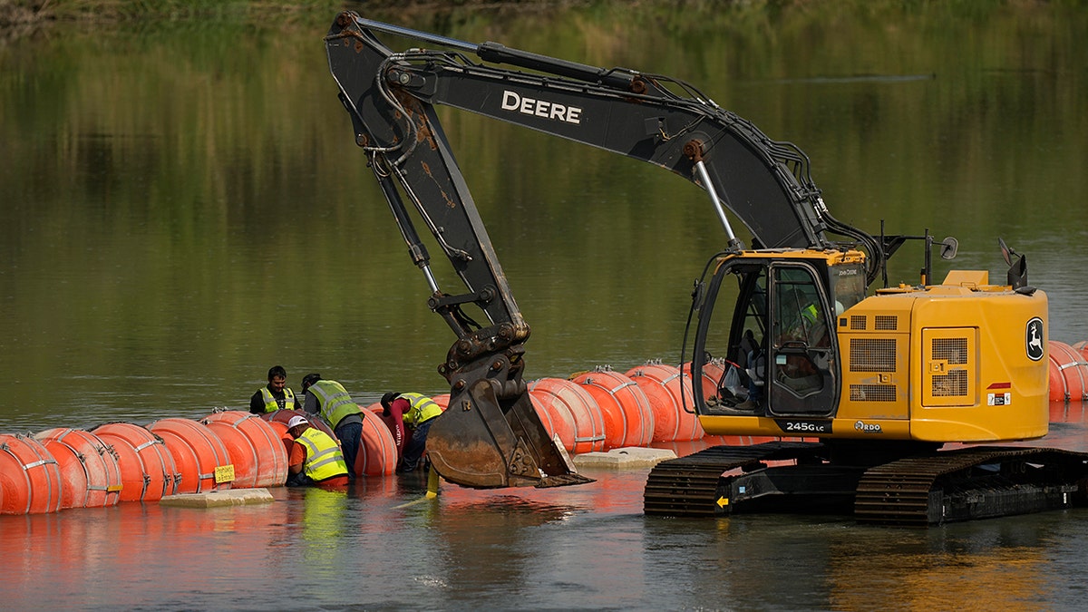 Workers make adjustments to buoys