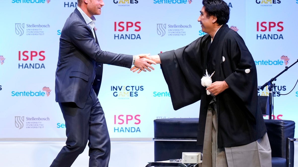 prince harry shaking hands with founder 