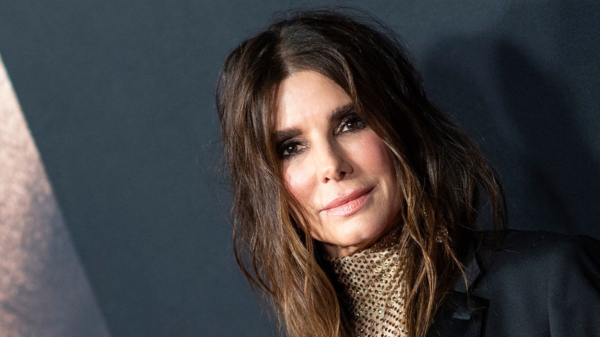 Sandra Bullock con una chaqueta negra y un vestido translúcido 