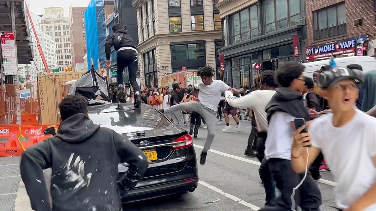 Kai Cenat rioters kick and jump on vehicles