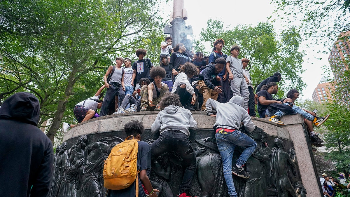 Union Square rioters climb on statue