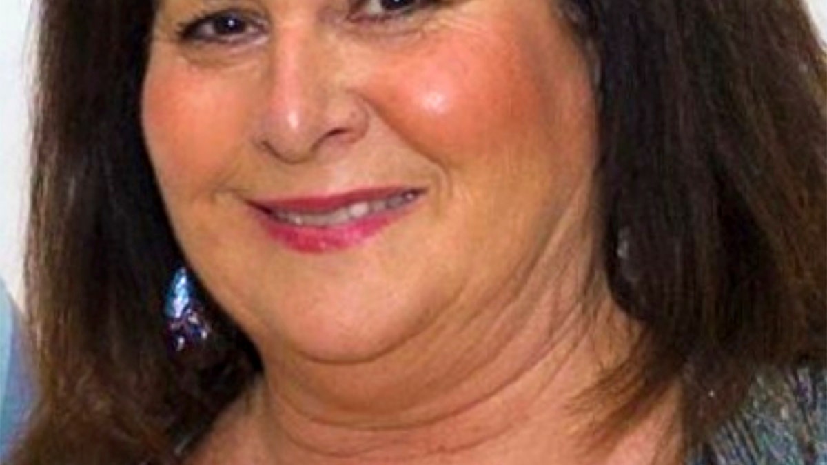 Victim Sheryl Ferguson smiles in undated photo, with dark hair, brown eyes and makeup on