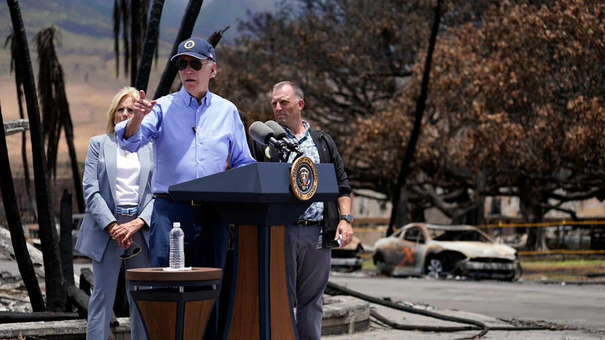 President Joe Biden speaks after touring areas devastated by the Maui wildfires, Monday, Aug. 21, 2023, in Lahaina, Hawaii. In the background is the massive Banyan Tree burned in the fire.