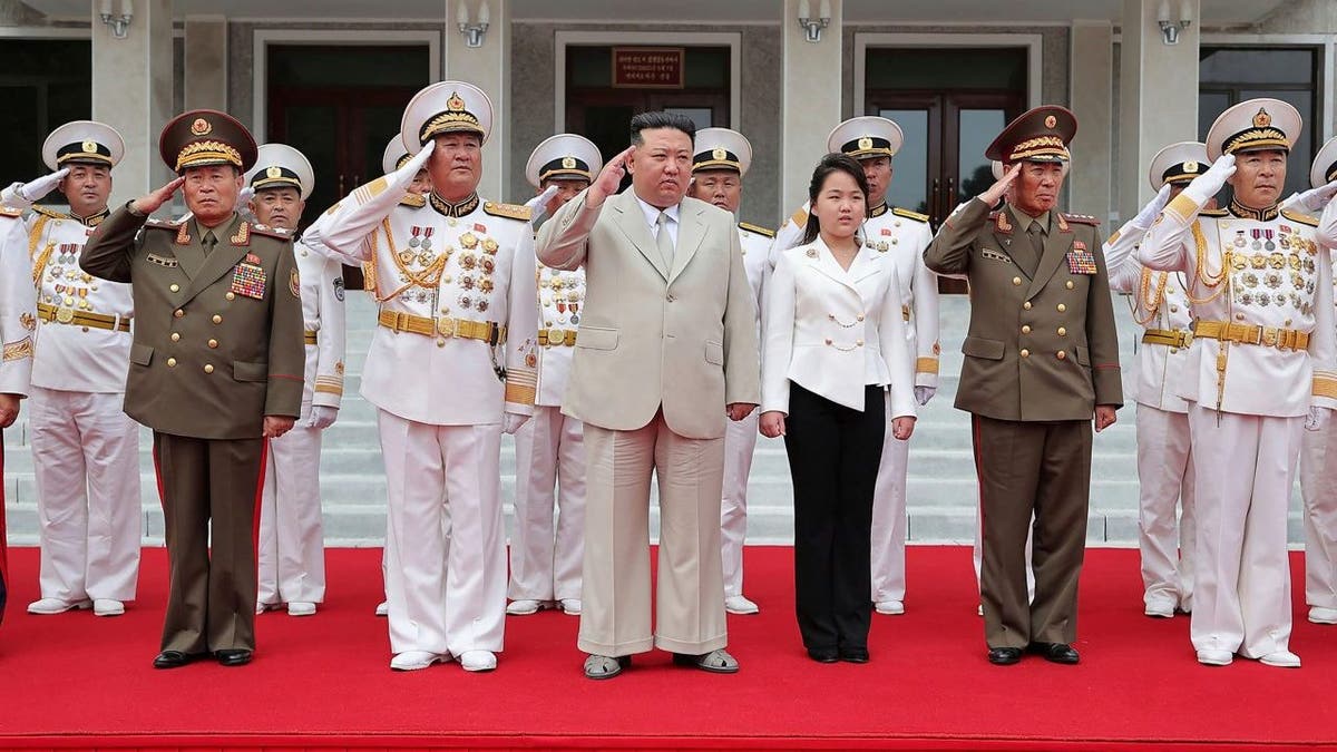 Photograph showing greeting Kim Jong Un with military officers.