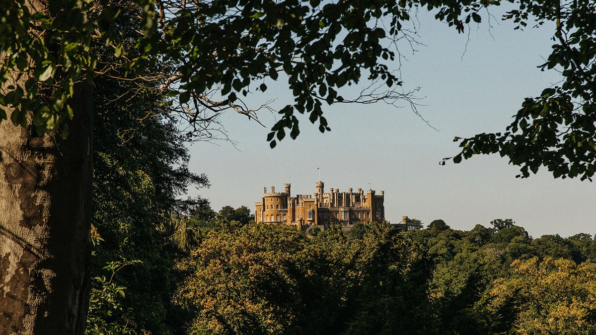 A landscape view of Belvoir Castle surrounded by trees