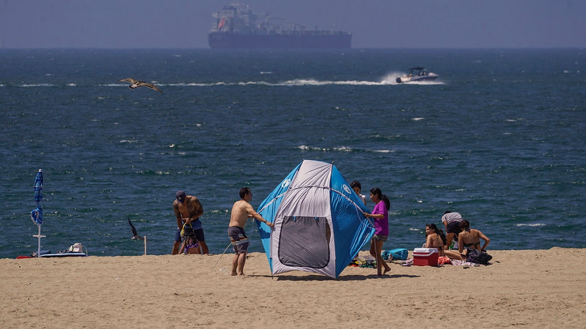Beach goers hold on to their beach tents