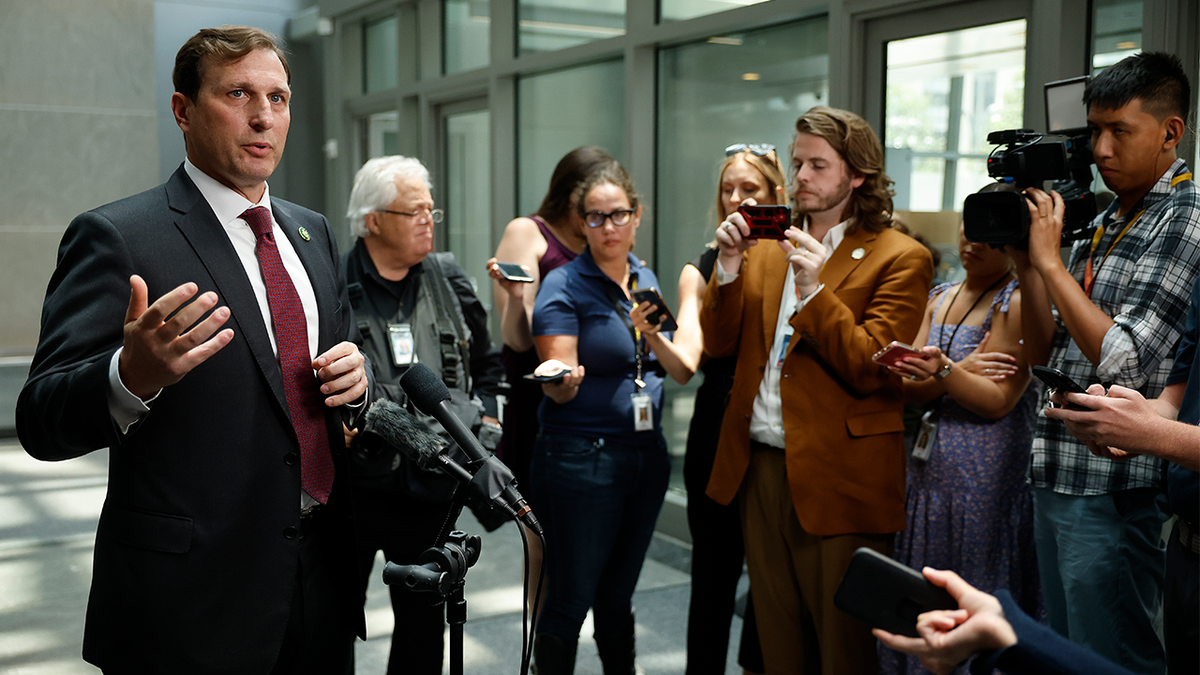 Dan Goldman, left, speaks to press gaggle