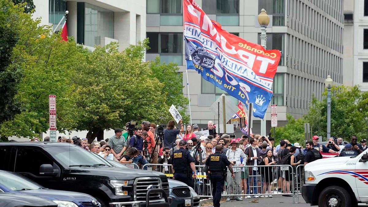 People watch after former President Donald Trump arrived at the E. Barrett Prettyman U.S. Federal Courthouse