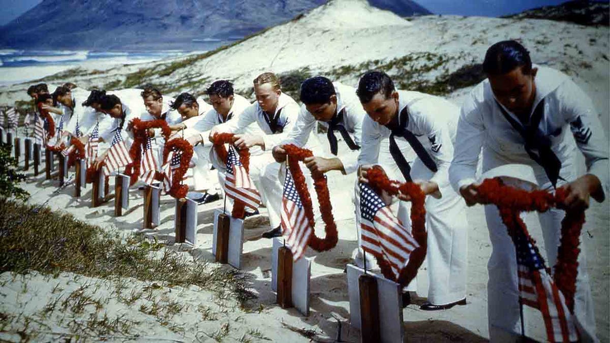 Sailors laying wreaths on graves