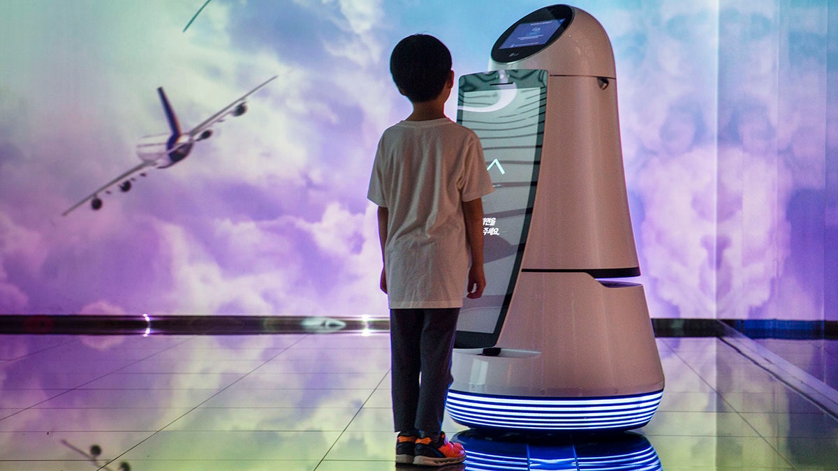 a boy interacts with a robot