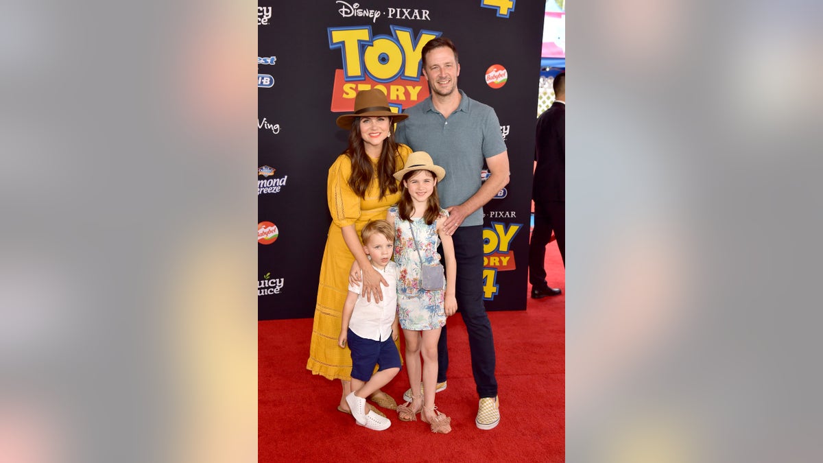 tiffani thiessen with her kids and husband on red carpet
