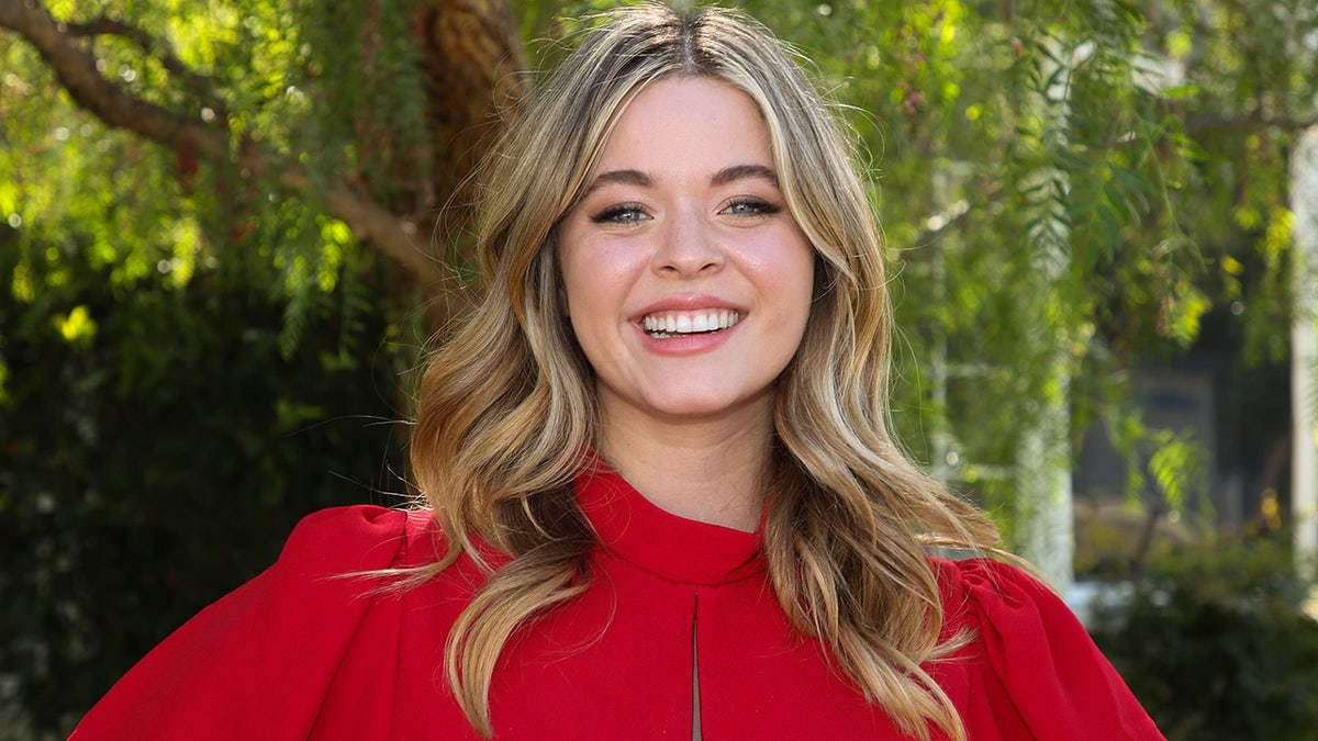 Sasha Pieterse smiles in a red dress in Universal City