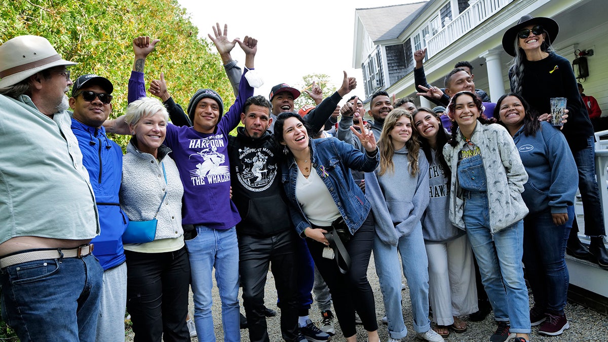 Migrants pose with Martha's Vineyard volunteers