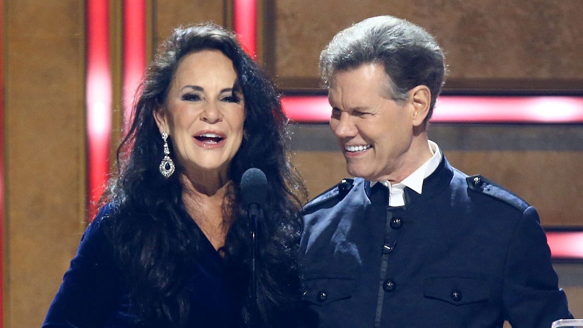 Randy Travis and wife Mary on stage as Mary speaks