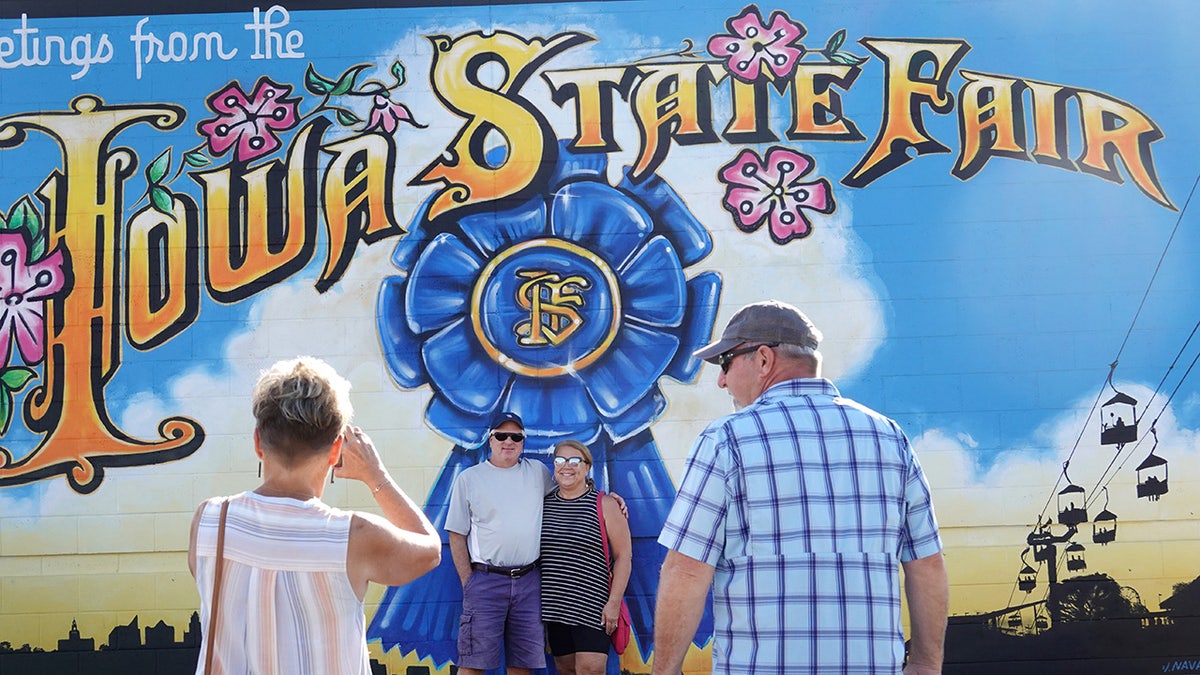 People take photos with the Iowa State Fair sign