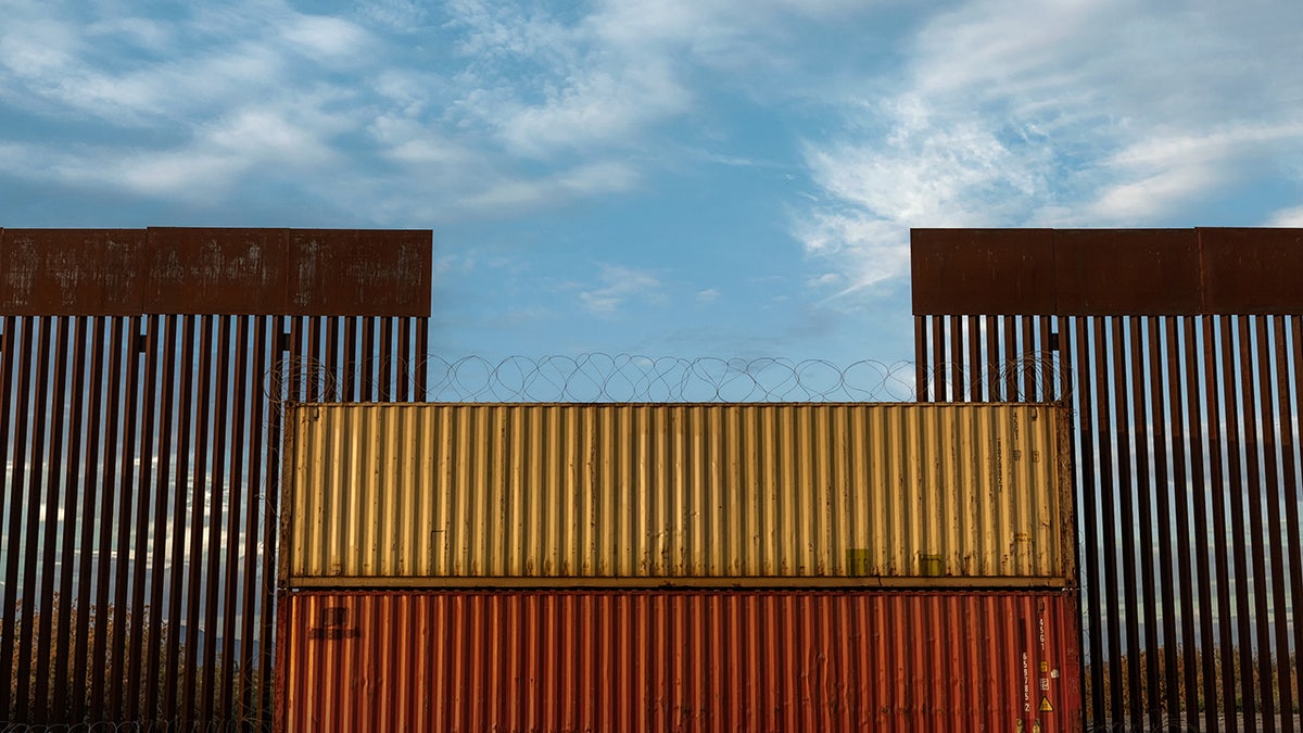 Border wall in Arizona covered with shipping crate