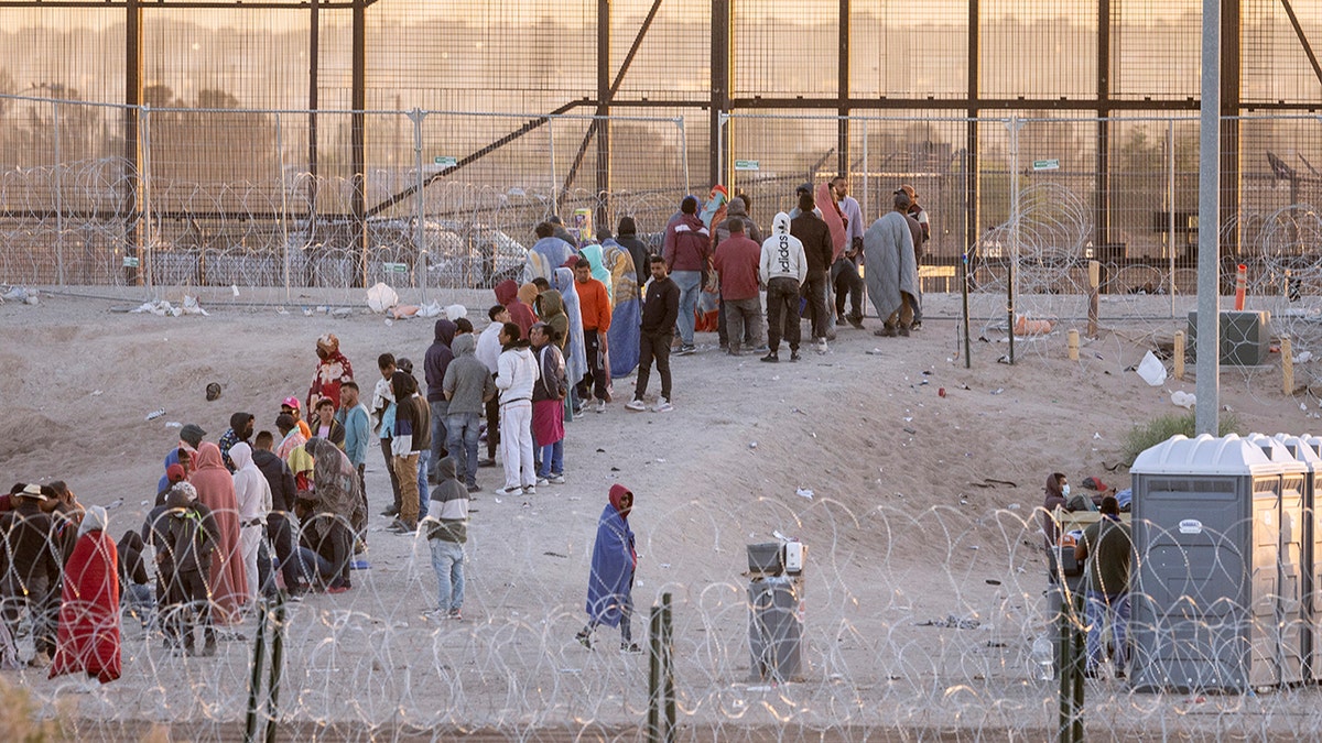 Migrants crowding near the border wall