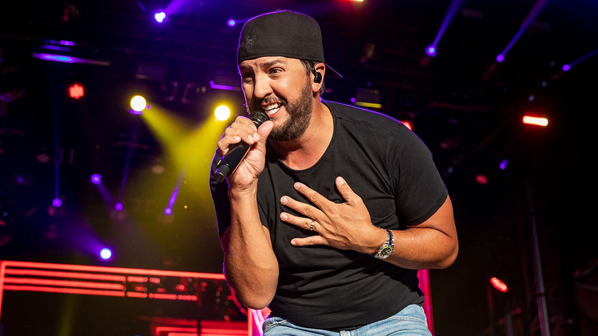 A photo of Luke Bryan singing in concert