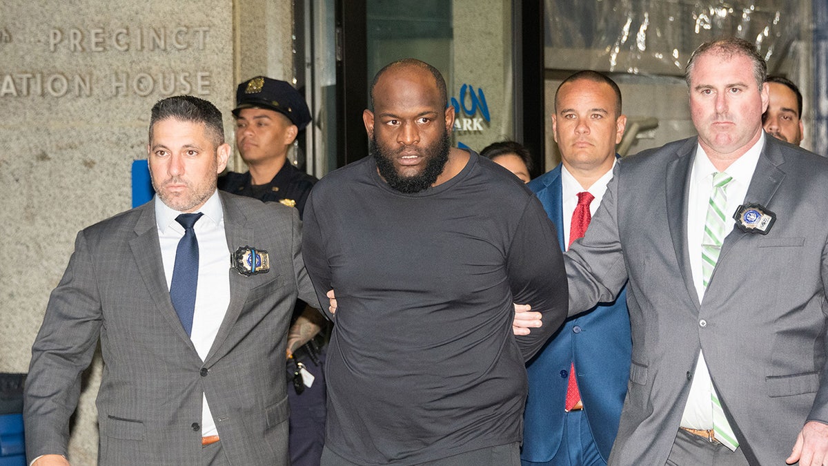 Claude White escorted out of NYPD precinct in handcuffs