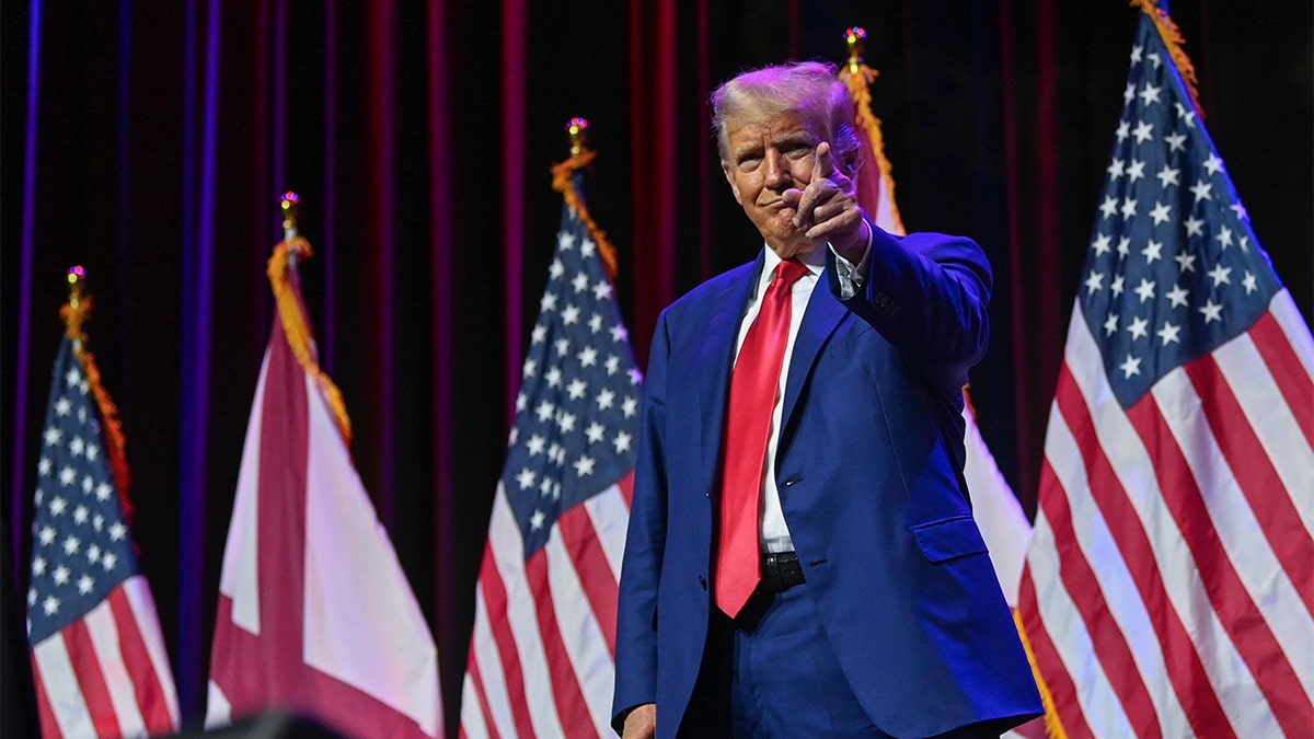 Former President Donald Trump on stage pointing to the crowd