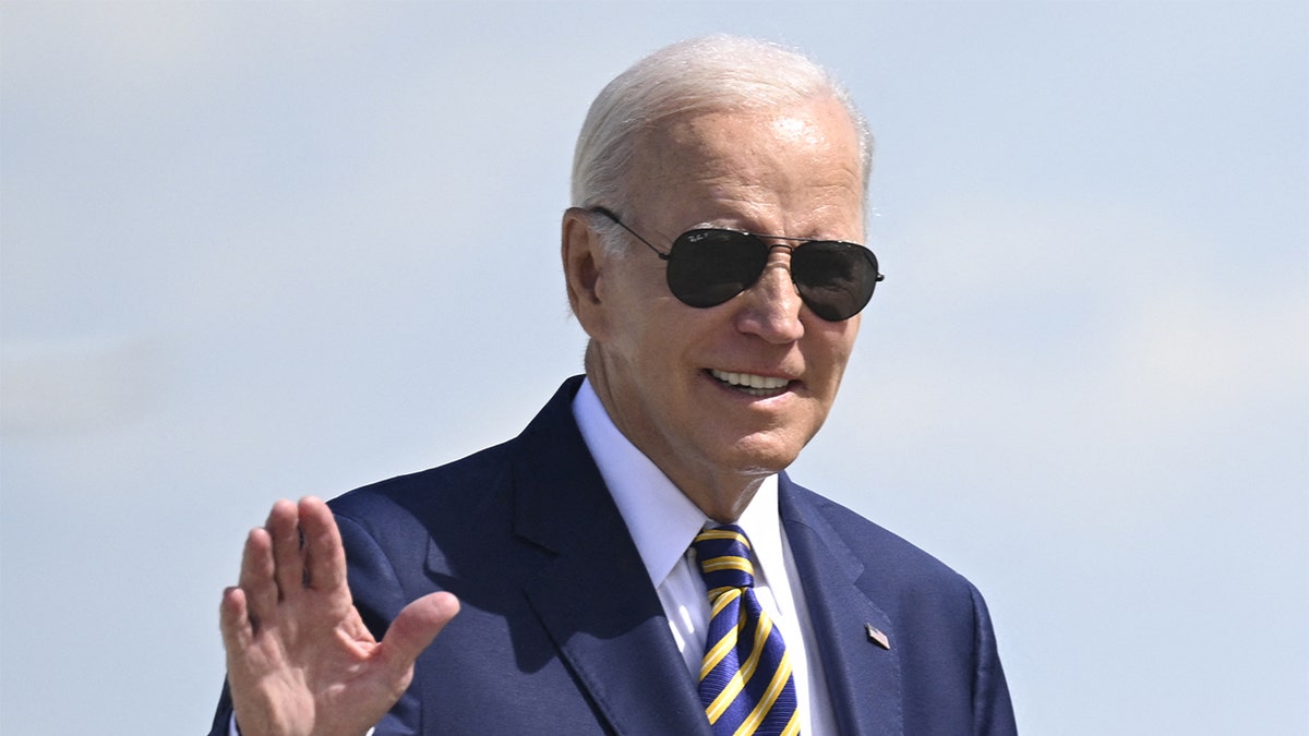 President Joe Biden in sunglasses waving