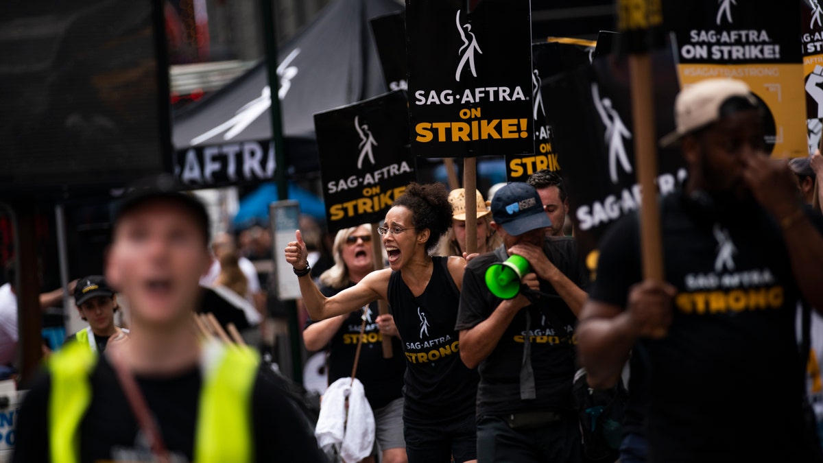 Protesters carrying SAG-AFTRA strike signs