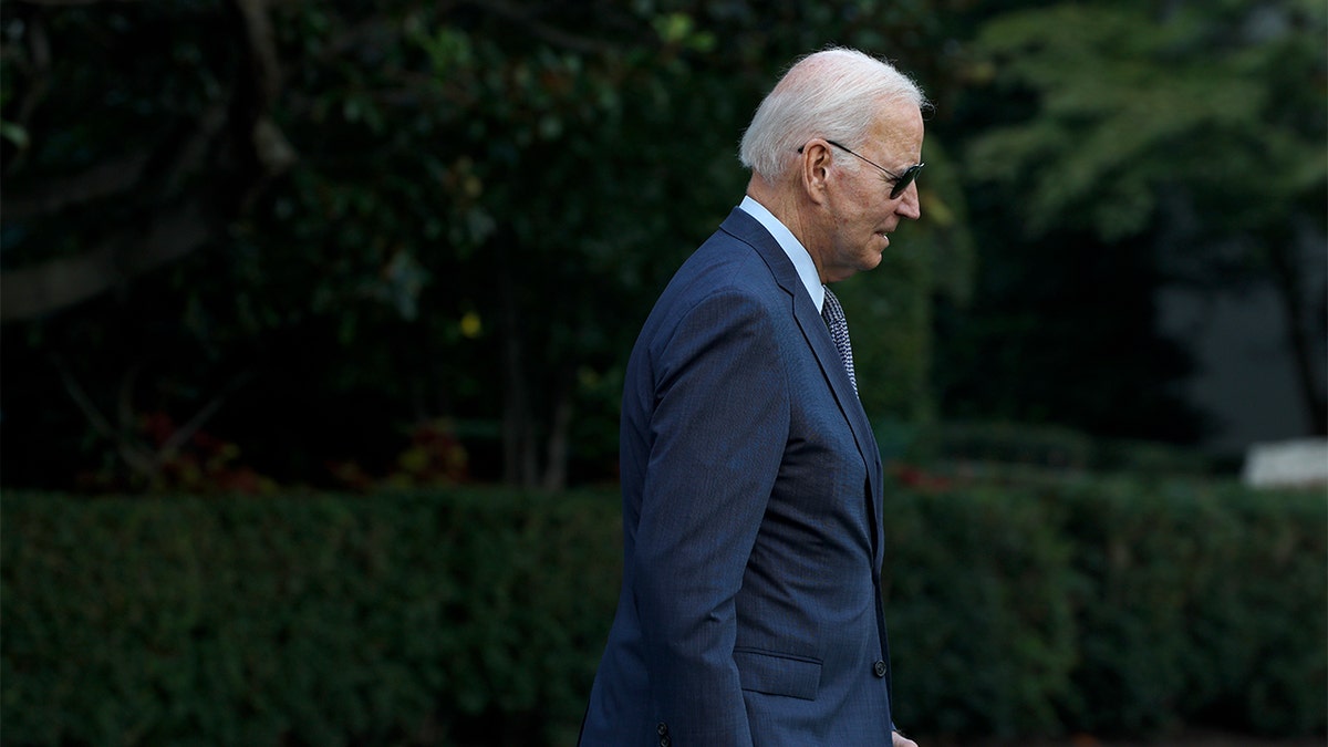 President Joe Biden walking on White House lawn wearing sunglasses