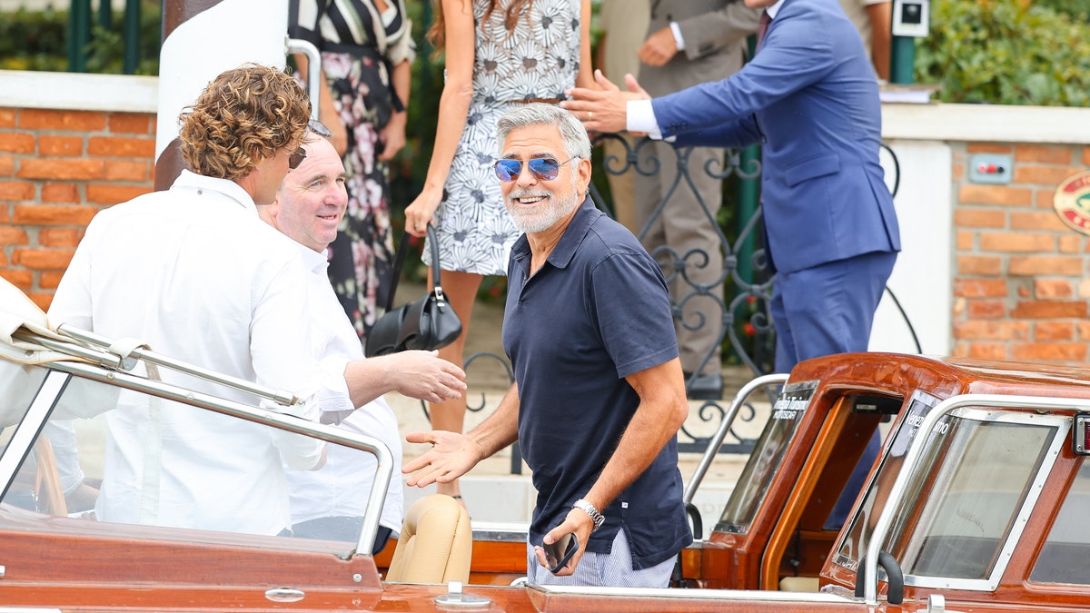 george clooney smiling on boat in venice