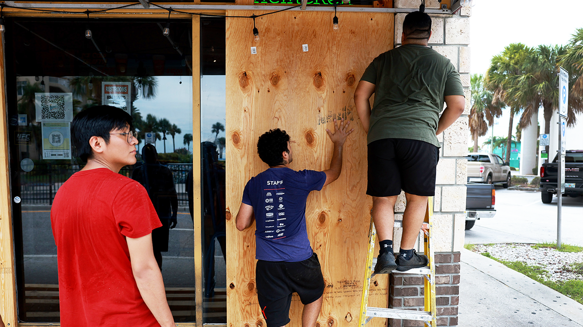 men boarding up for Hurricane Idalia