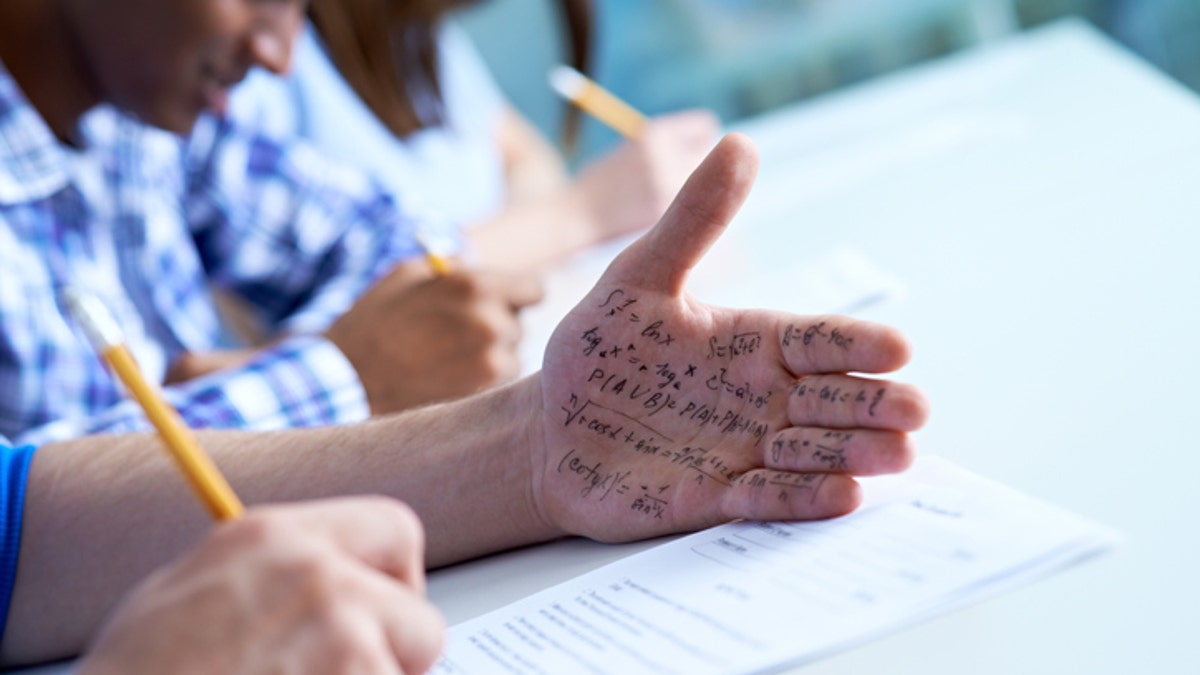 Student cheating on a test with text on his hand