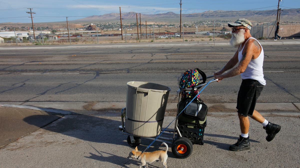 Homeless man shown walking through an arid desert in San Bernardino County