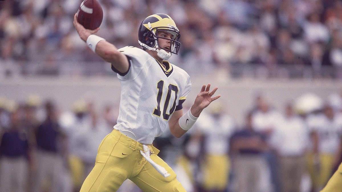 Tom Brady lanza un pase con el uniforme de los Wolverines de Michigan