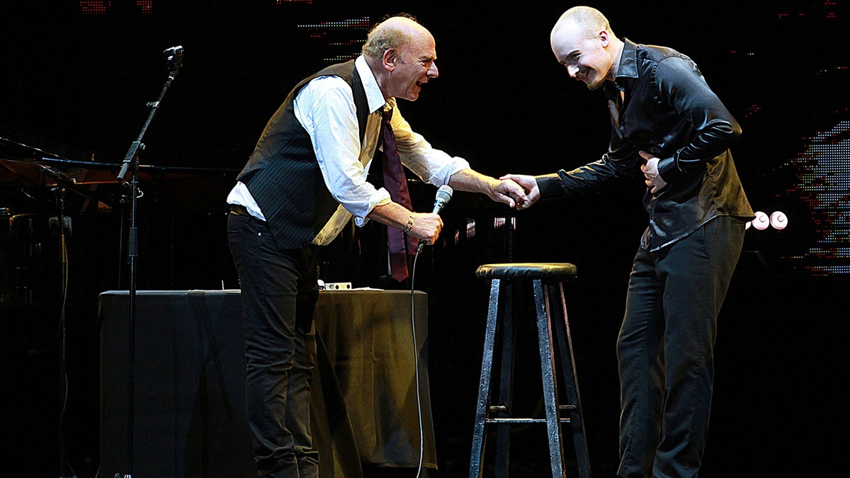 Art Garfunkel and his son smiling on stage and performing together