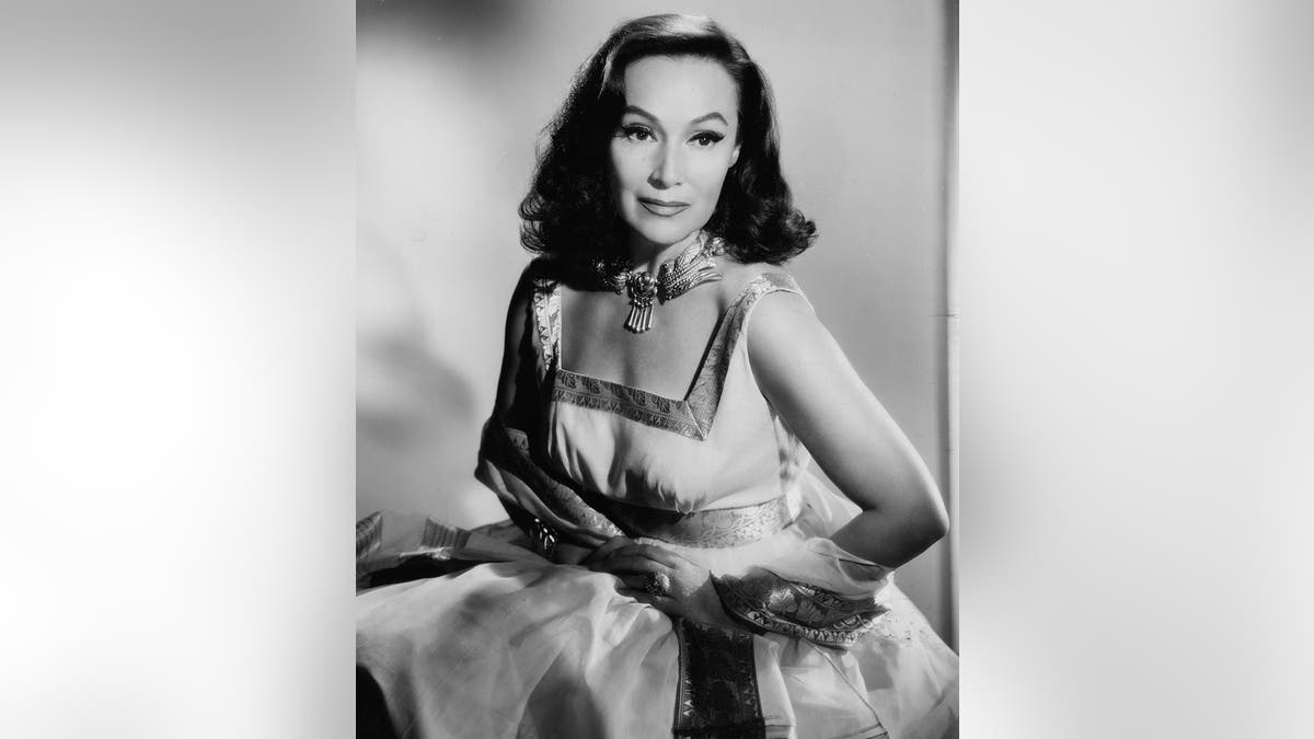 Dolores Del Rio posing in a sleeveless dress and scarf