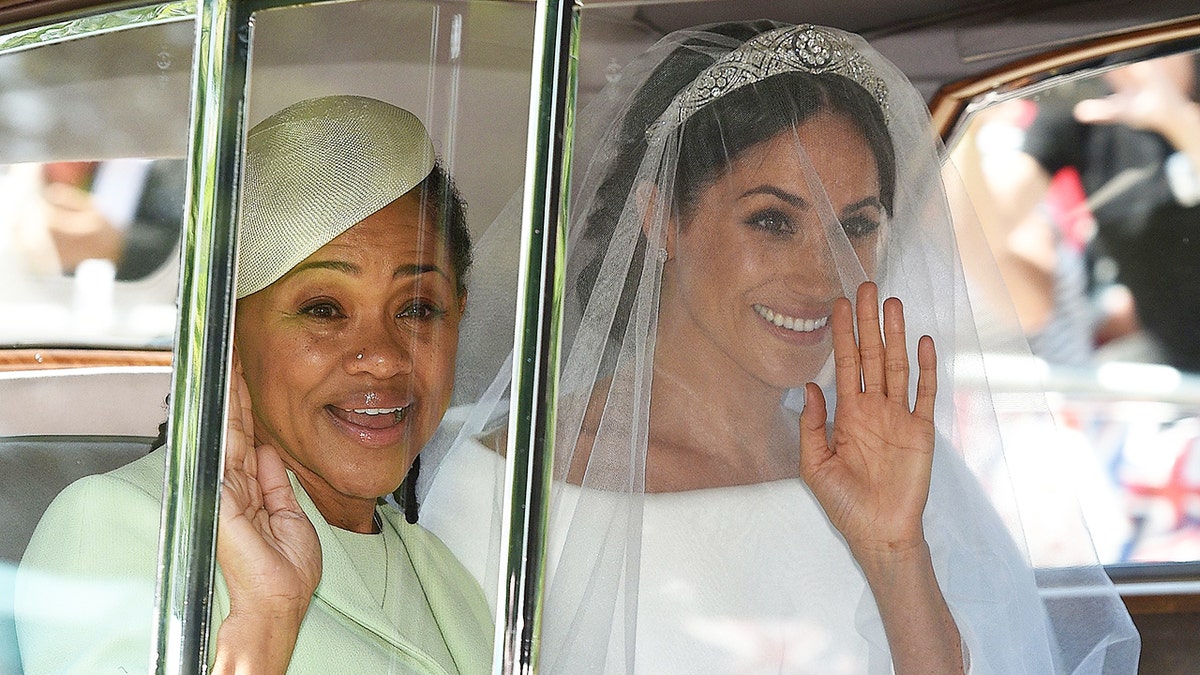 Meghan Markle wearing a bridal gown sitting next to her mother Doria Ragland in a lime green dress with a matching hat