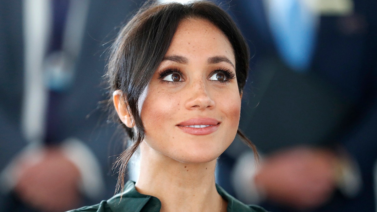 A close-up of Meghan Markle wearing a green dress