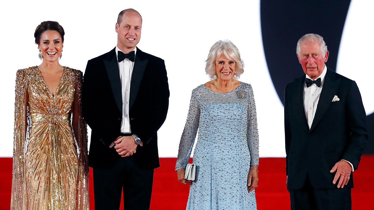 Kate Middleton in a sparkling gold dress standing next to Prince William in a tux, Queen Camilla in a sky blue dress and King Charles III in a tux