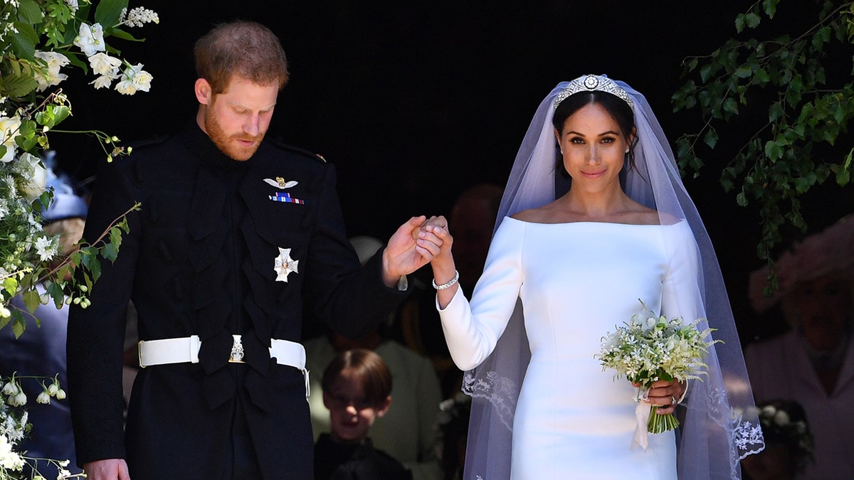 Prince Harry holding Meghan Markle's hand on their wedding day