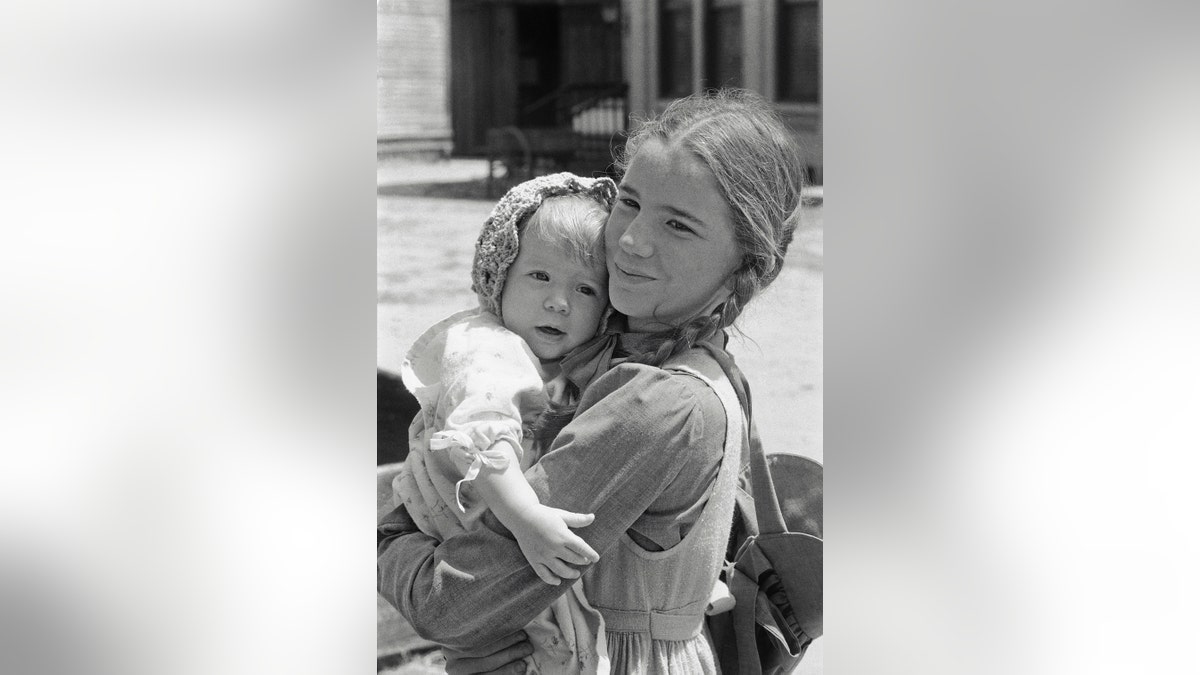 Melissa Gilbert in costume holding onto either Wendi Lee or her twin sister on set