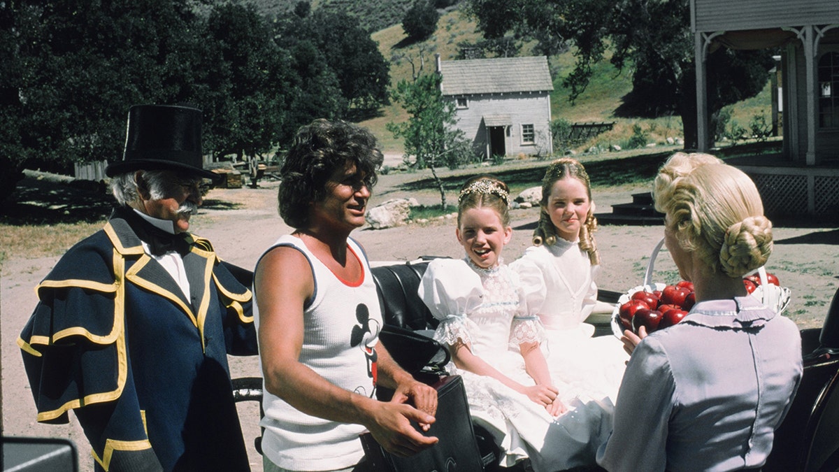 Michael Landon in a Mickey Mouse tank top directing his castmates in costume