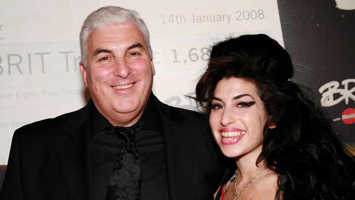 Amy Winehouse smiling backstage with her father Mitch Winehouse