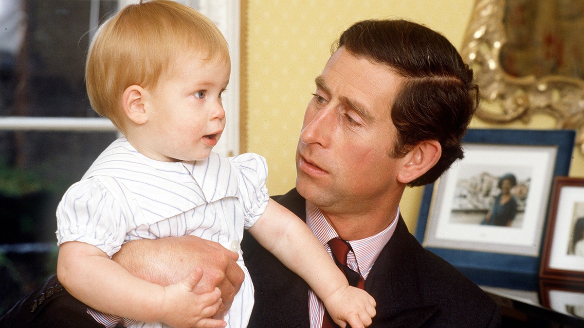 A close-up of Prince Charles holding a baby Prince Harry